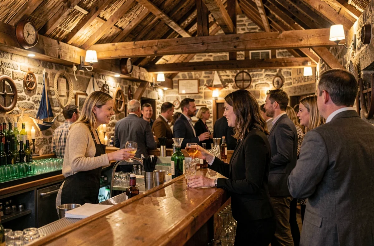 Intérieur rustique de La Chaumière avec poutres en bois apparentes, murs en pierre et bar animé au décor marin breton